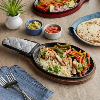 Choice 9 1/4" x 7" Oval Pre-Seasoned Cast Iron Fajita Skillet with Oak Finish Wood Underliner and Gray Silicone Handle Cover
