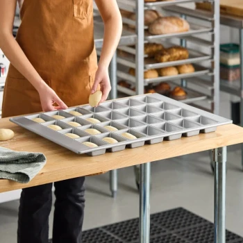 Baker's Lane 28 Compartment Glazed Aluminized Steel Mini Bread Pan - 6 oz. Capacity, 4 inch x 2 1/2 inch x 1 1/4 inch Cavities